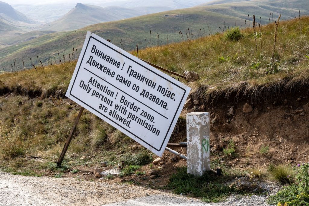 A warning sign in a border zone, written in Russian and English, stating that only persons with permission are allowed.