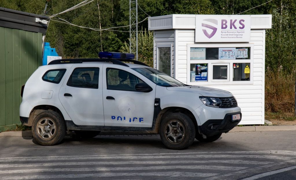 A police vehicle parked near a security booth with a sign that says 'BKS'.